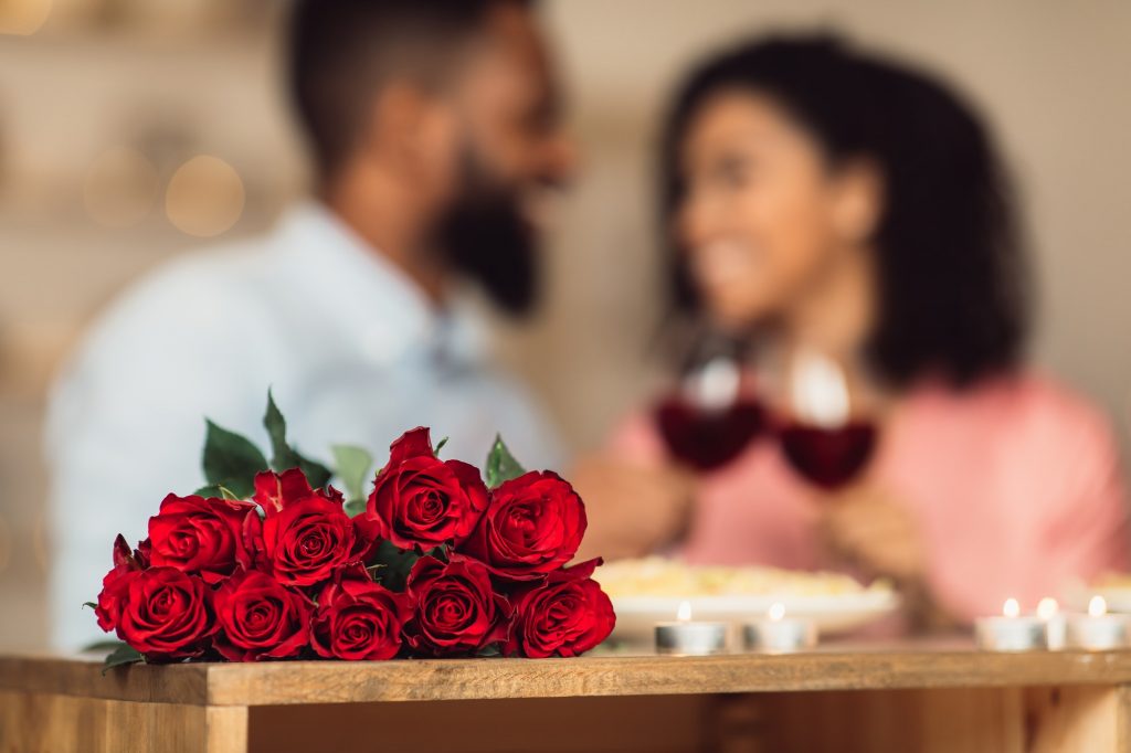 Black couple having dinner, focus on red roses